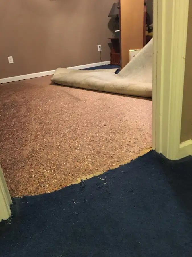 Carpet pad removal revealing water damage during Water Mitigation Services in Baton Rouge